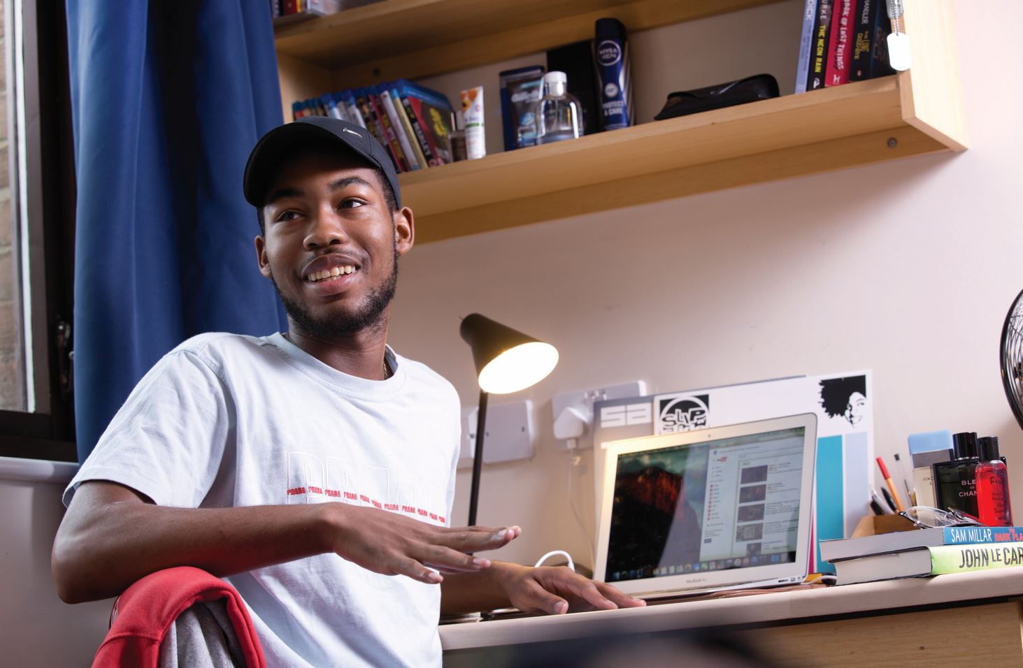 A student sat within accommodation on a laptop
