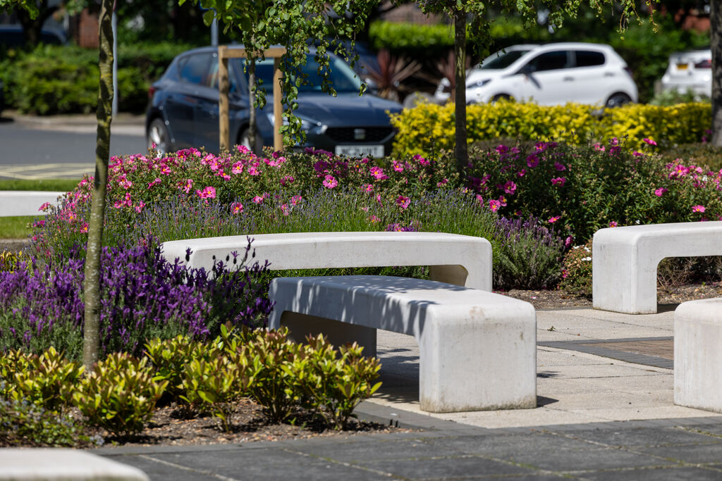 Cars Parked behind a well landscaped seating area