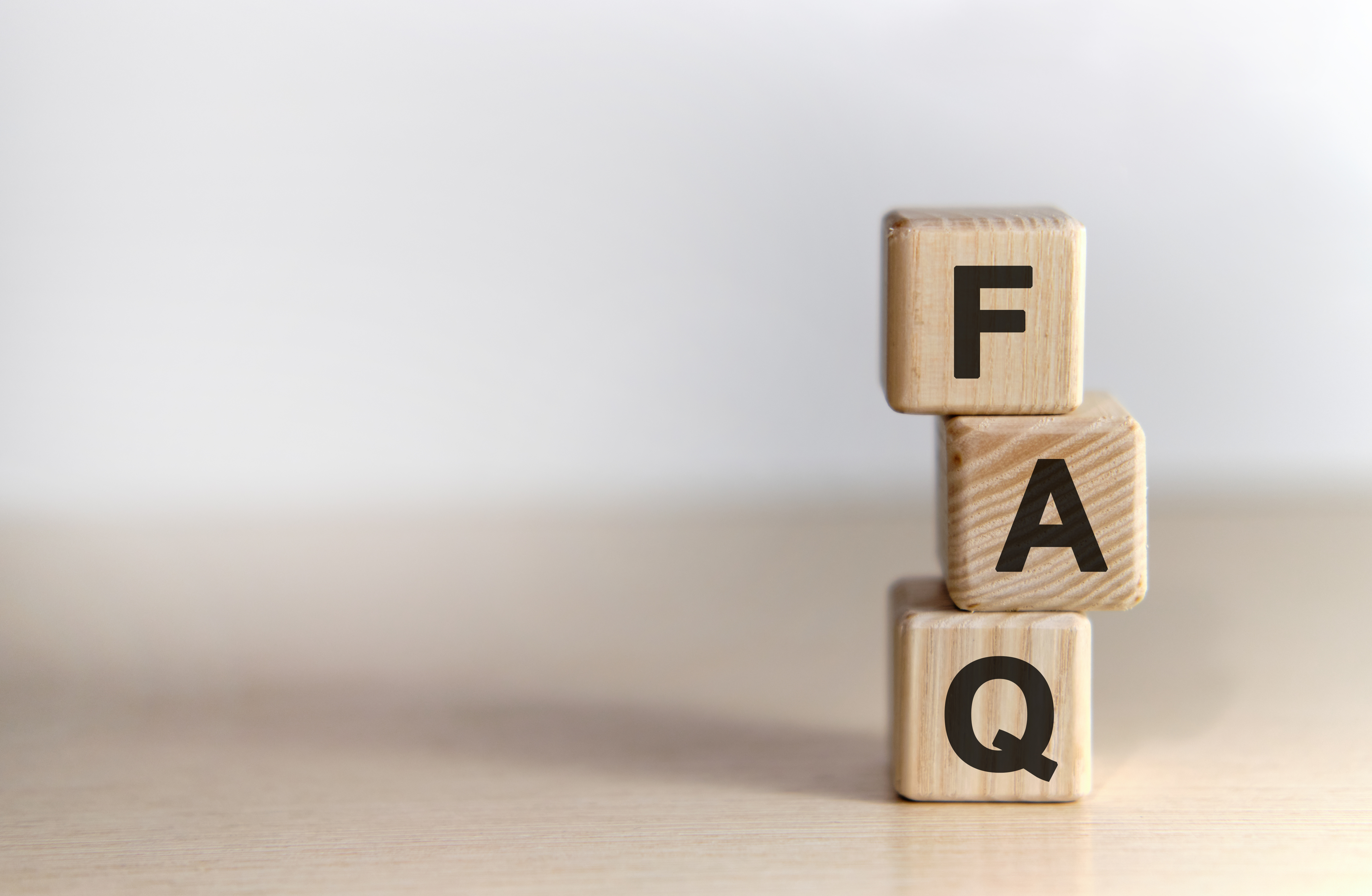 Three stacked wooden cubes. Top to bottom they spell F A Q