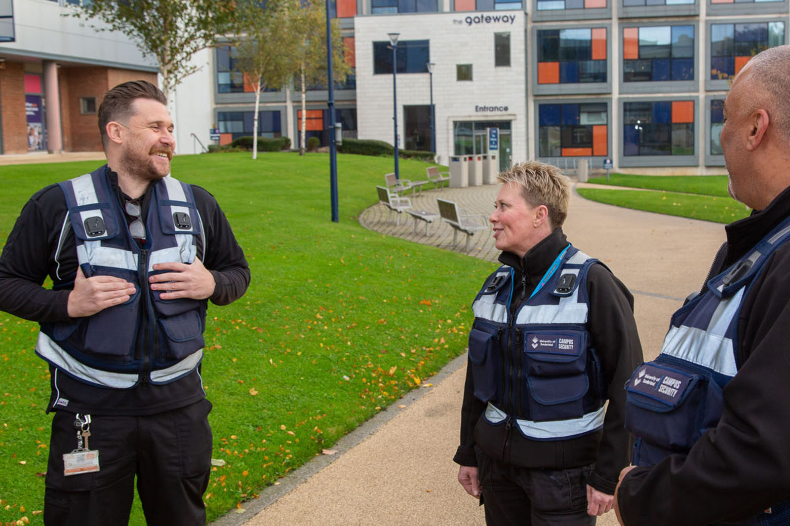 The University Security team in uniform talking and laughing on campus