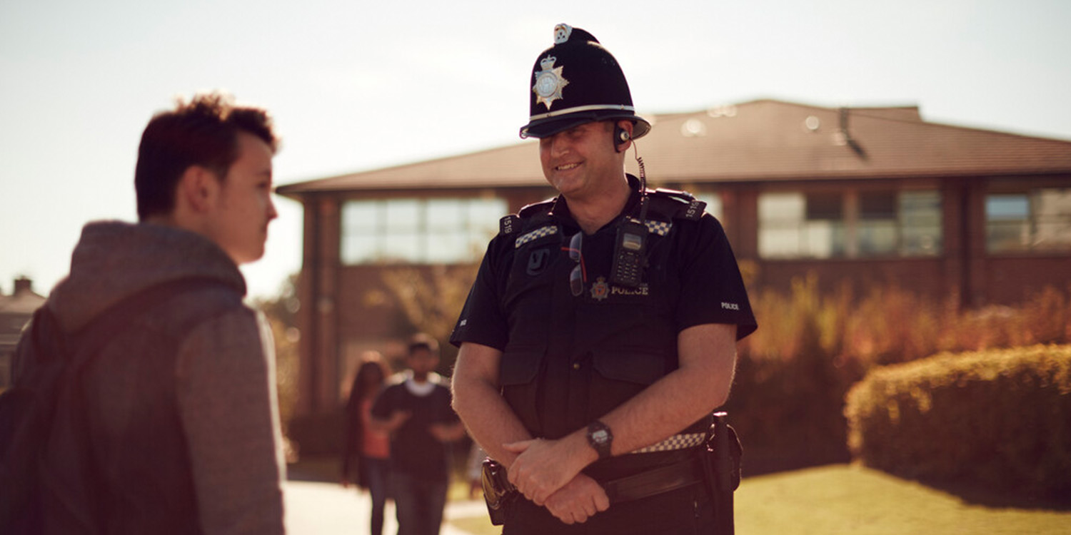 A police officer talking to a student on campus